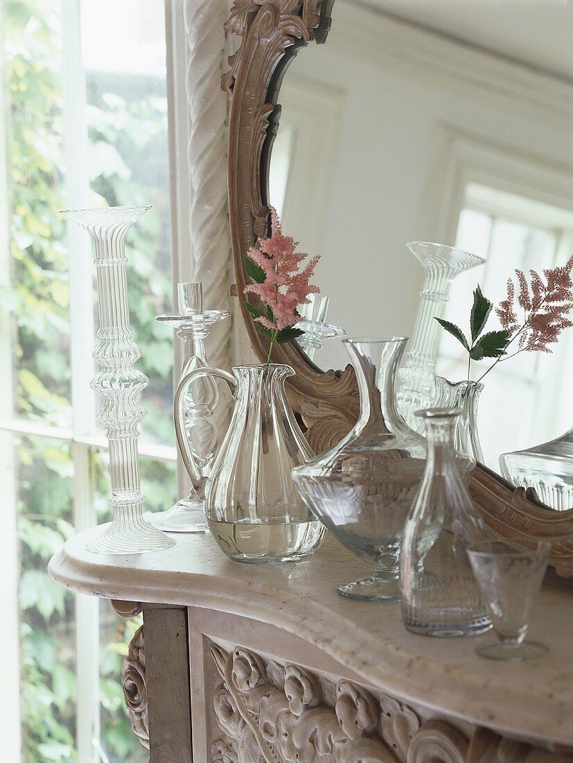 Zarte Blumendeko in Glasvasen vor Spiegel