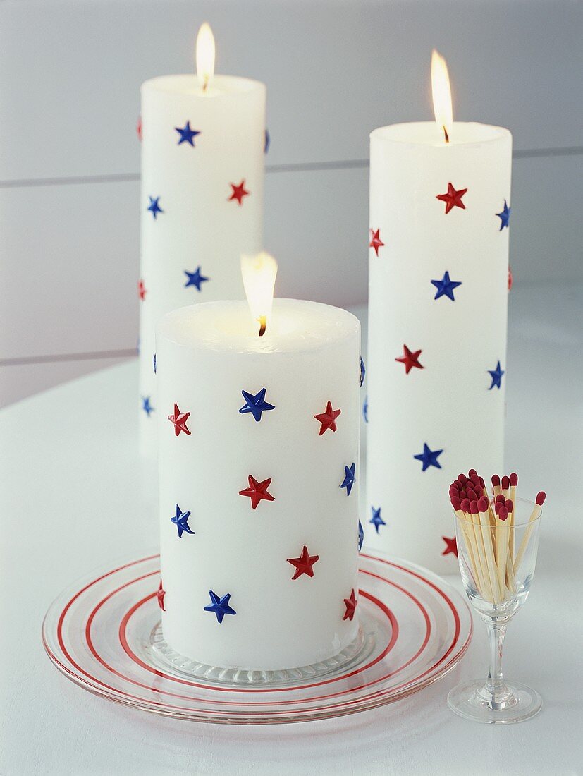 weiße Kerzen mit roten und blauen Sternen, Streichhölzer