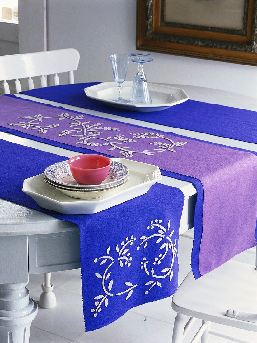 Blue and purple table runners, crockery and glasses