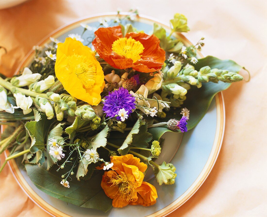 Teller mit verschiedenen Blumen als Tischdeko