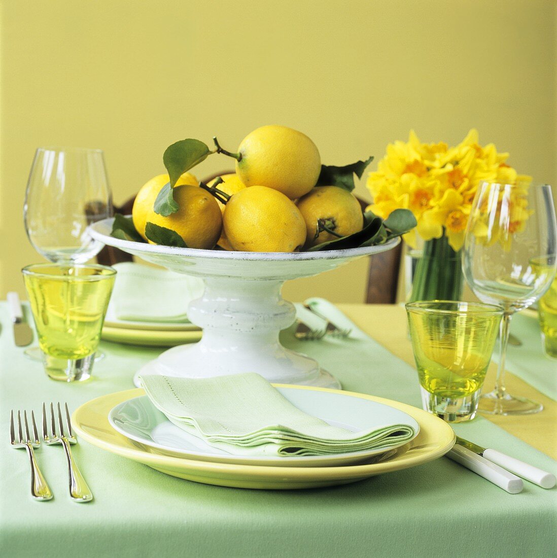 Schale mit Zitronen auf gedecktem Tisch für zwei Personen