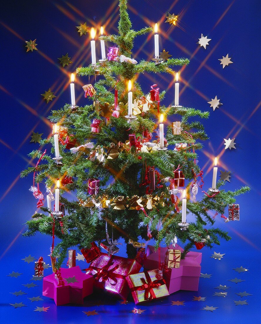 Decorated Christmas tree with candles and gifts