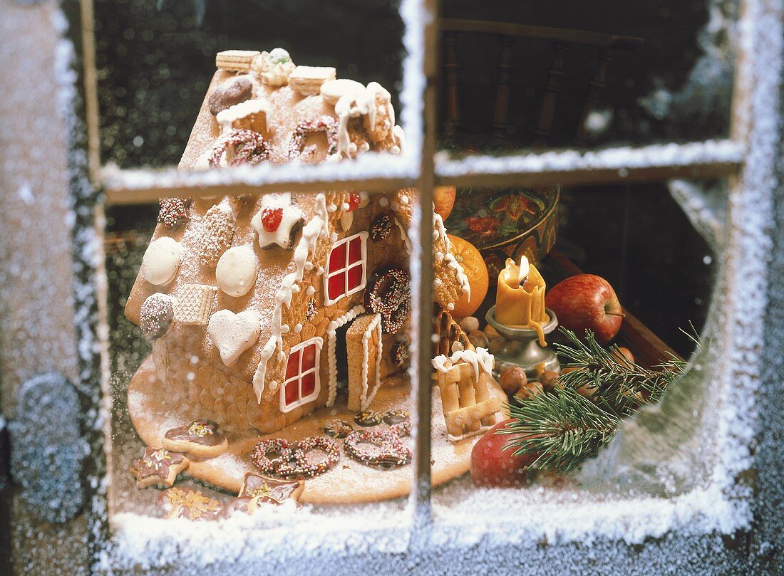 Gingerbread house through a snowy window