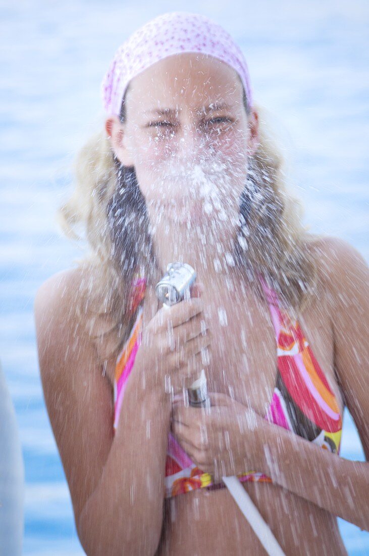 Young woman spraying water