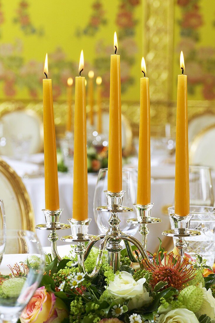 Kerzenleuchter mit Blumengesteck als festliche Tischdeko