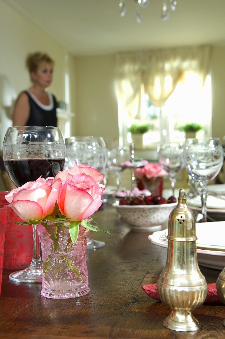 Gedeckter Tisch mit Wein und Rosendeko