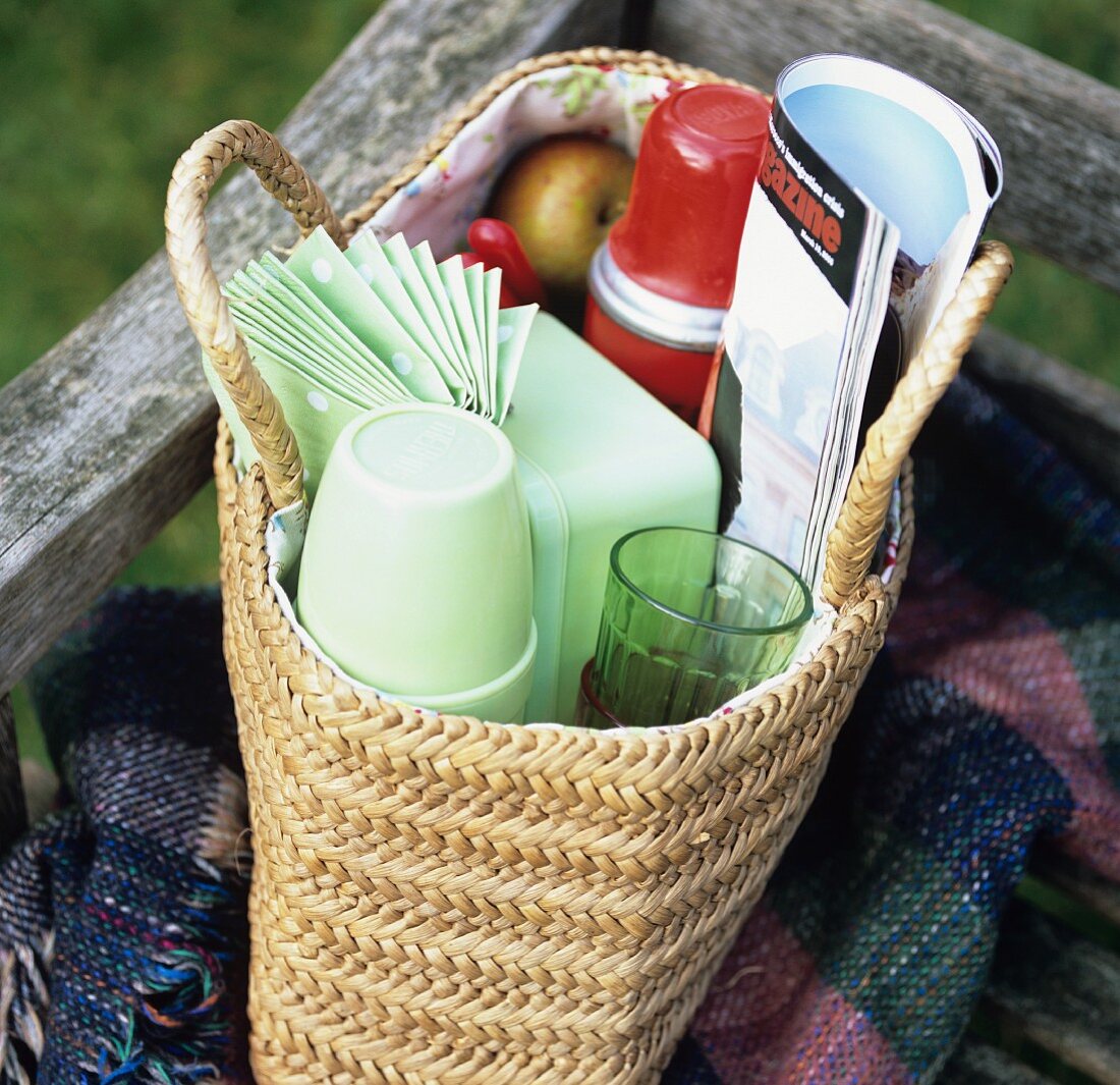 Basket of picnic things on a wooden bench