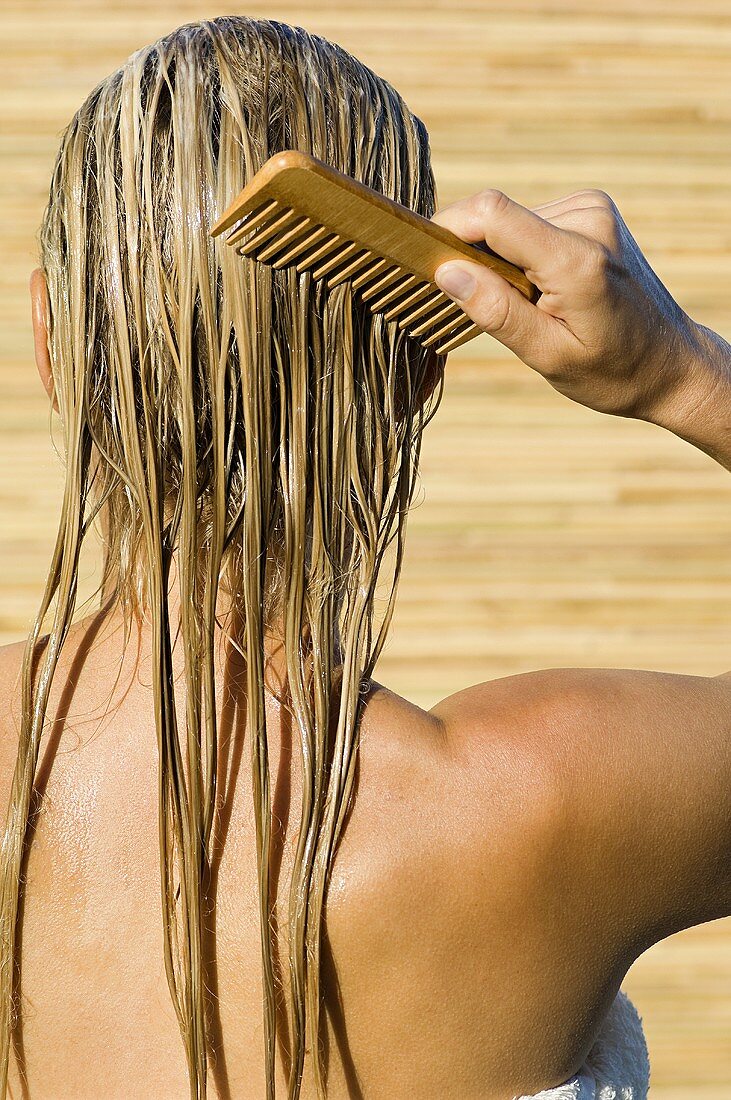 Rear view of a woman combing her hair