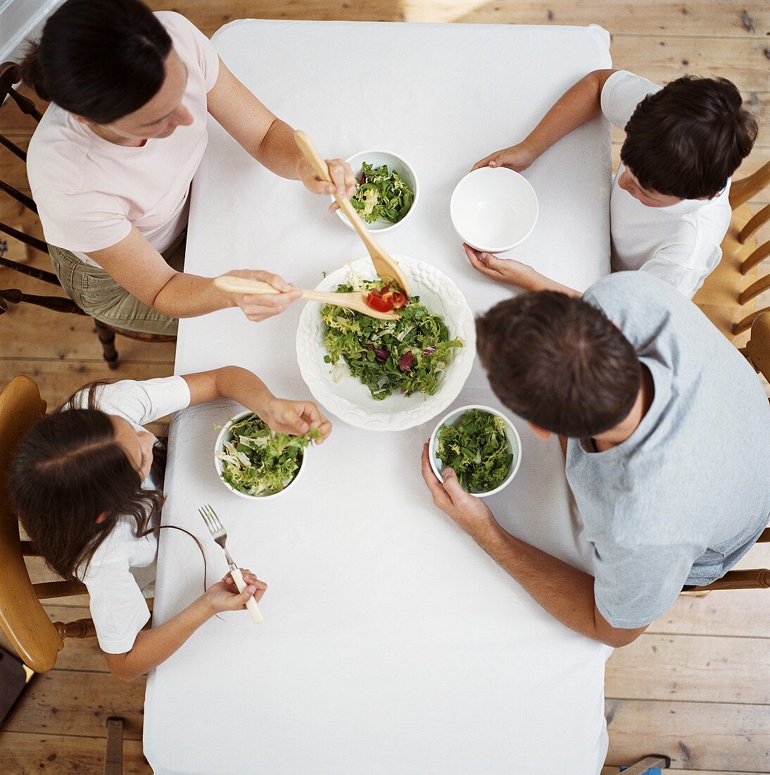 Familie isst Salat bei Tisch