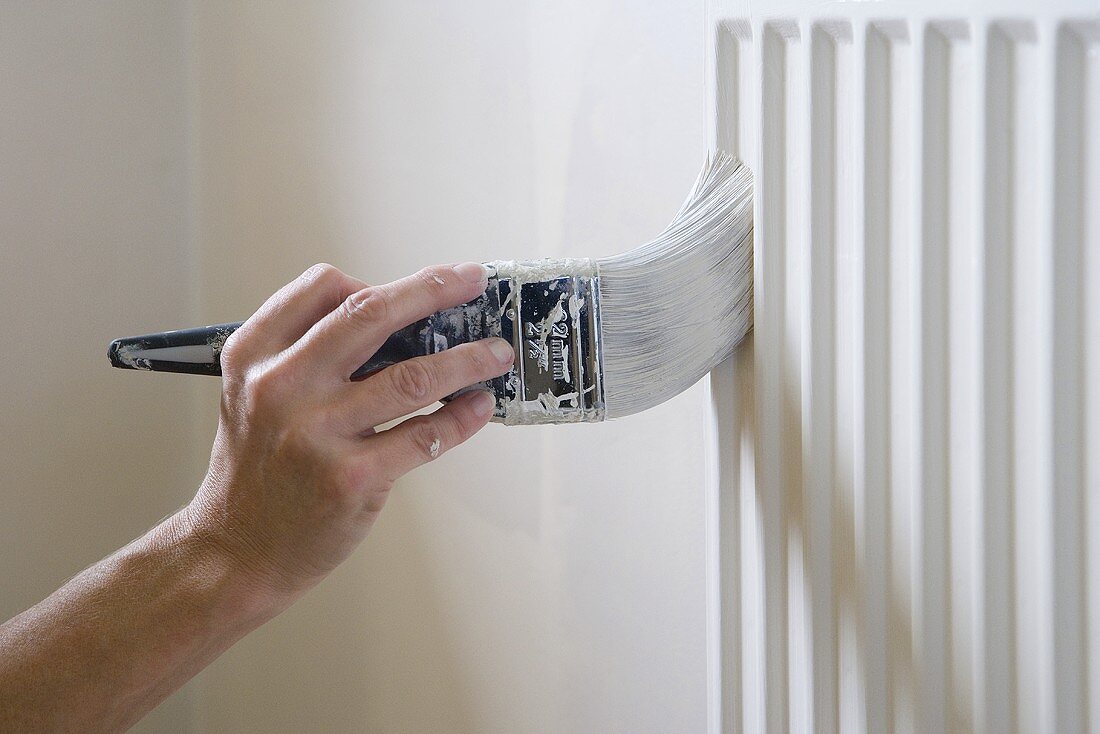 A man painting a radiator