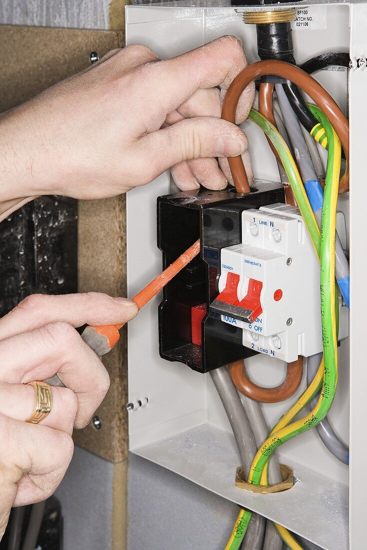 An electrician fixing a fuse box