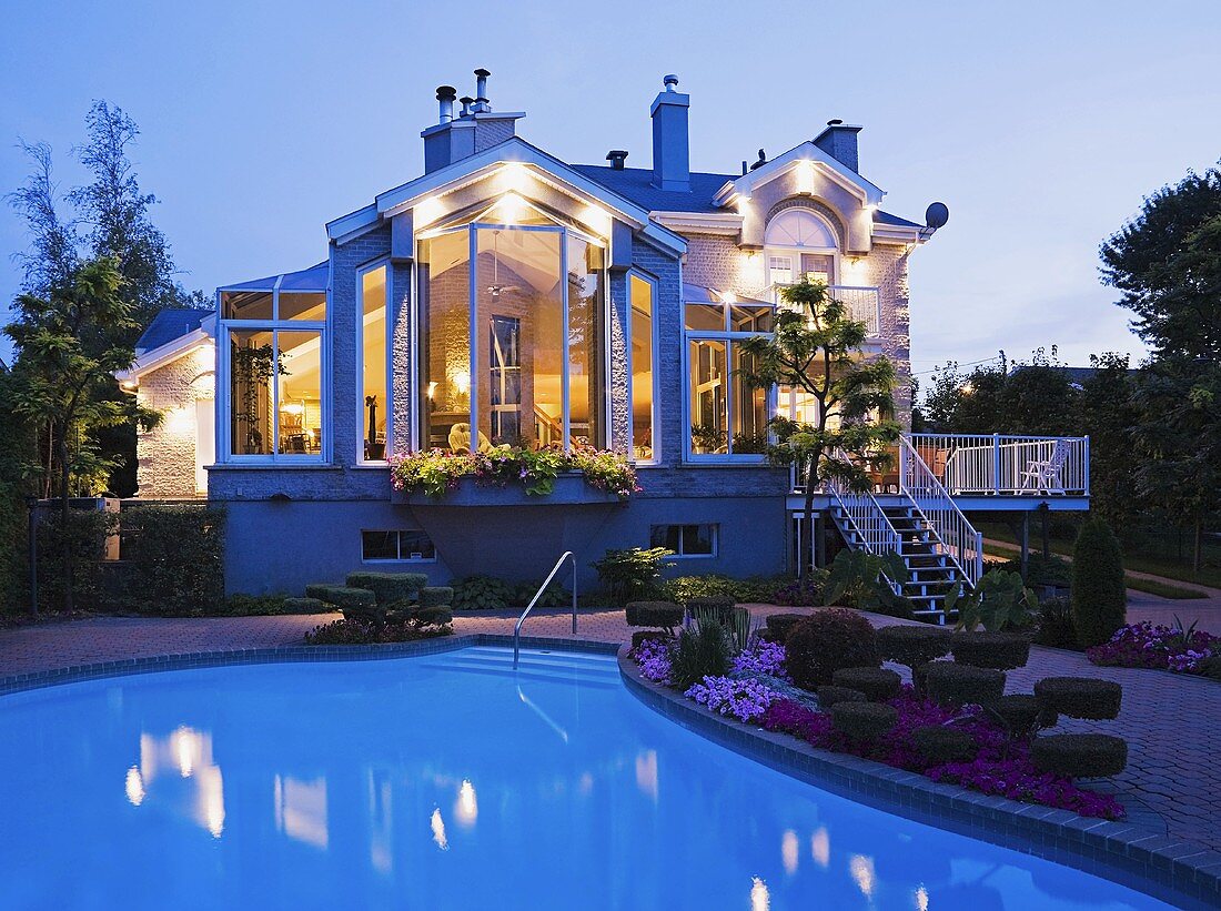 Grosses, verwinkeltes Haus mit Pool in der Abenddämmerung