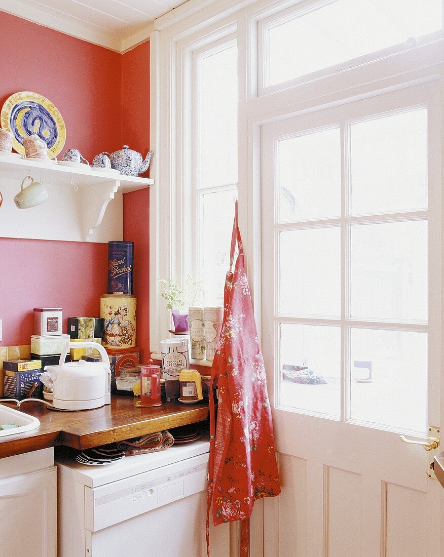 Helle, freundliche Küchenecke mit Fenstertür und orangefarbener Wand