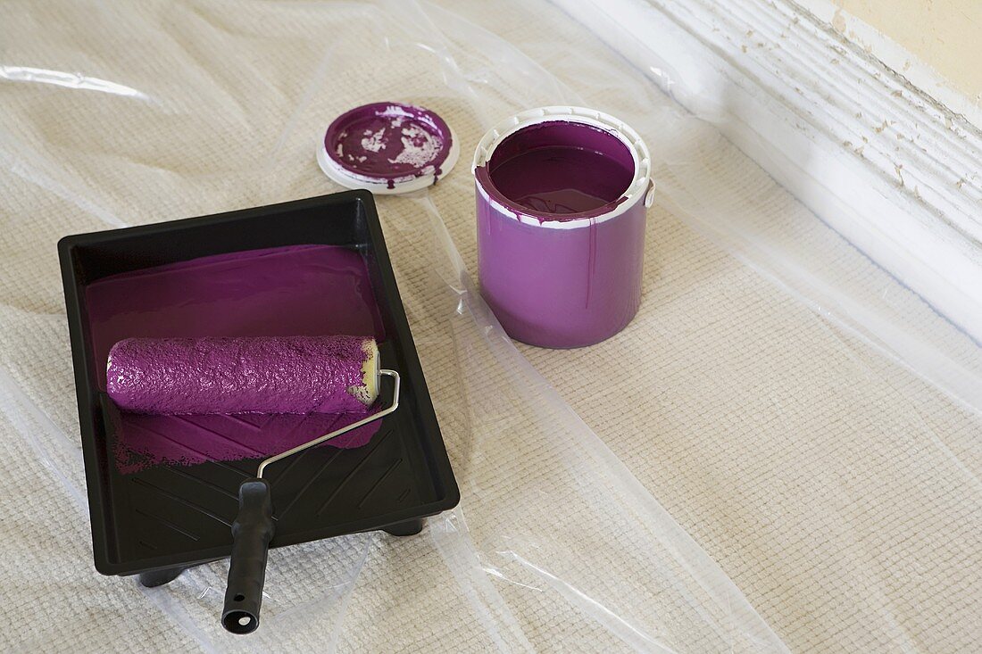A paint roller with purple paint