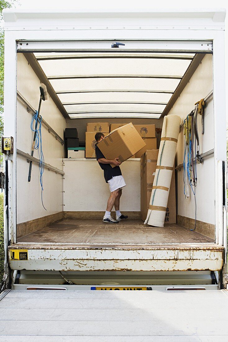 A man with removal boxes in a van