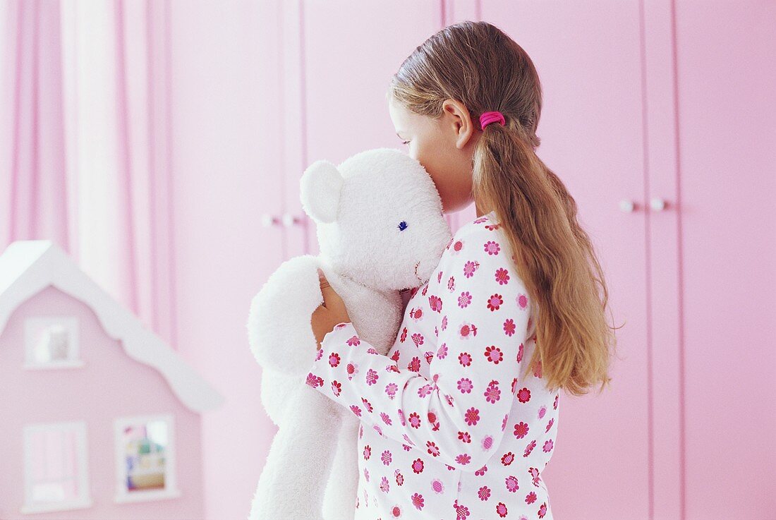 Mädchen umarmt ihren Teddybär