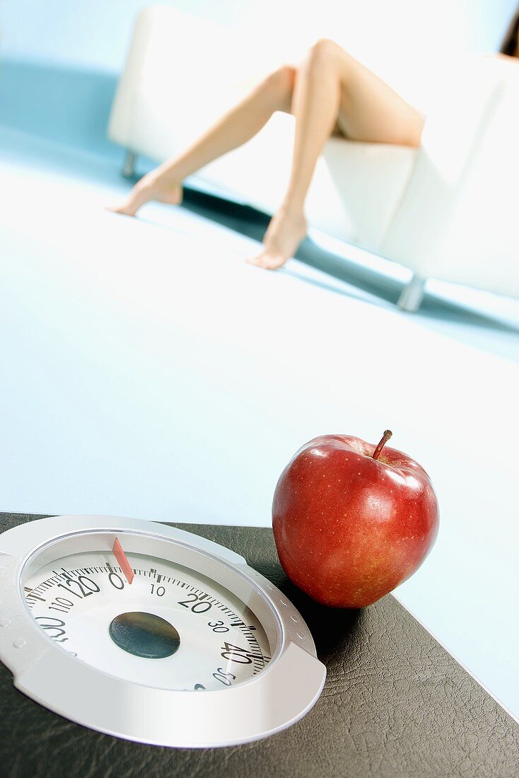 A red apple on bathroom scales (symbolising diet)