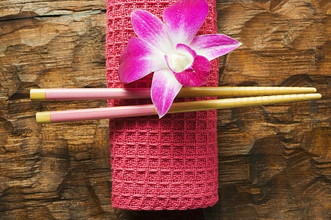 Asian table accessories: hand towel, chopsticks and orchid