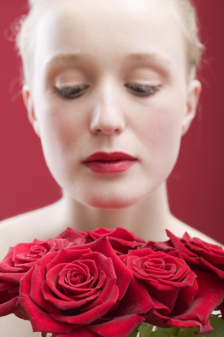 Junge Frau mit Strauss aus roten Rosen