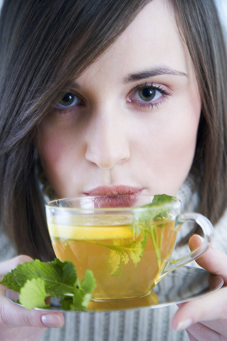 Young woman with lemon and mint tea