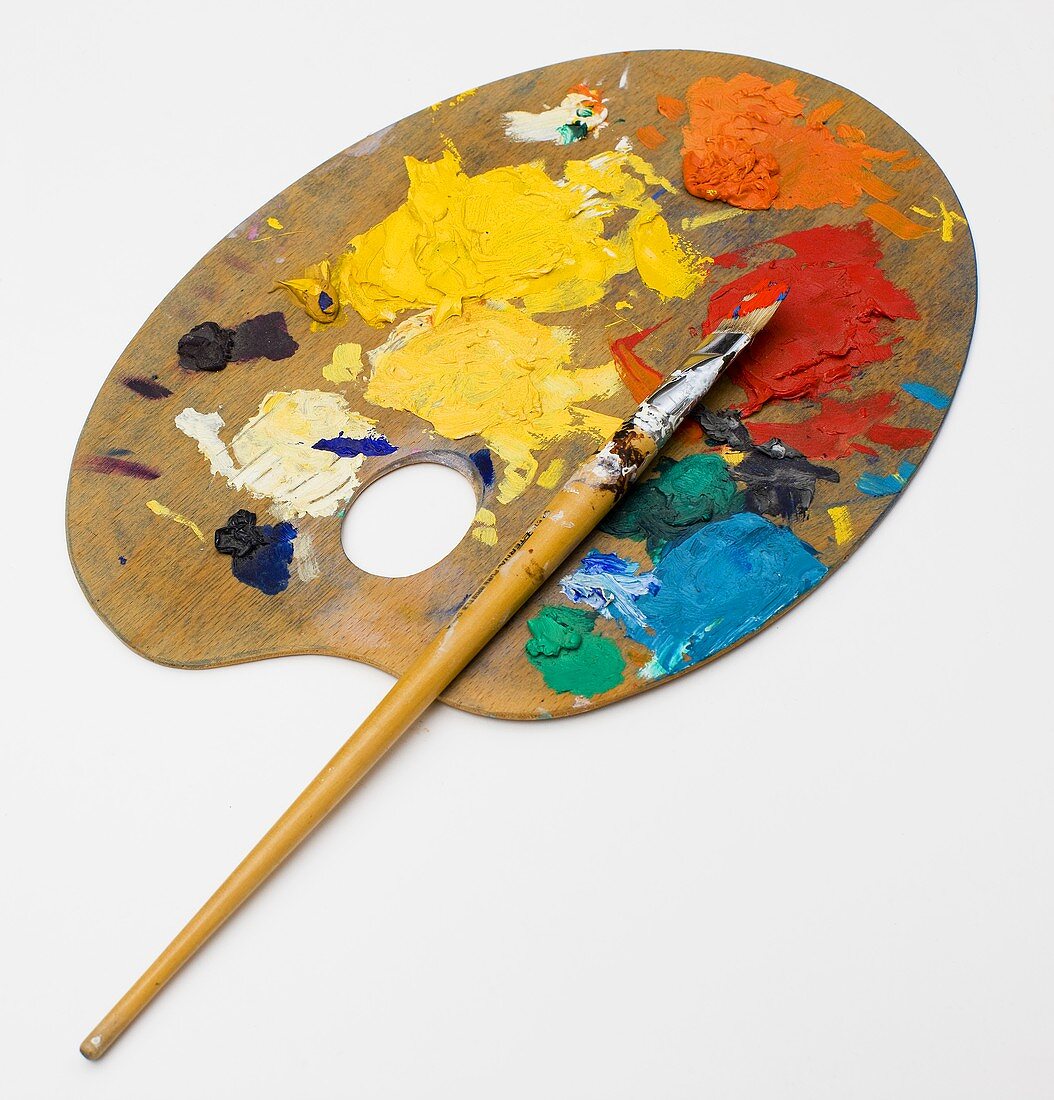 Artist's palette with paint in front of a white background
