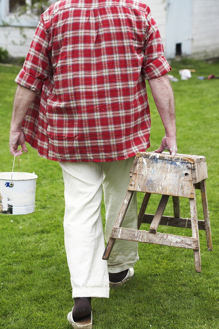 Man carrying paint pot & bench