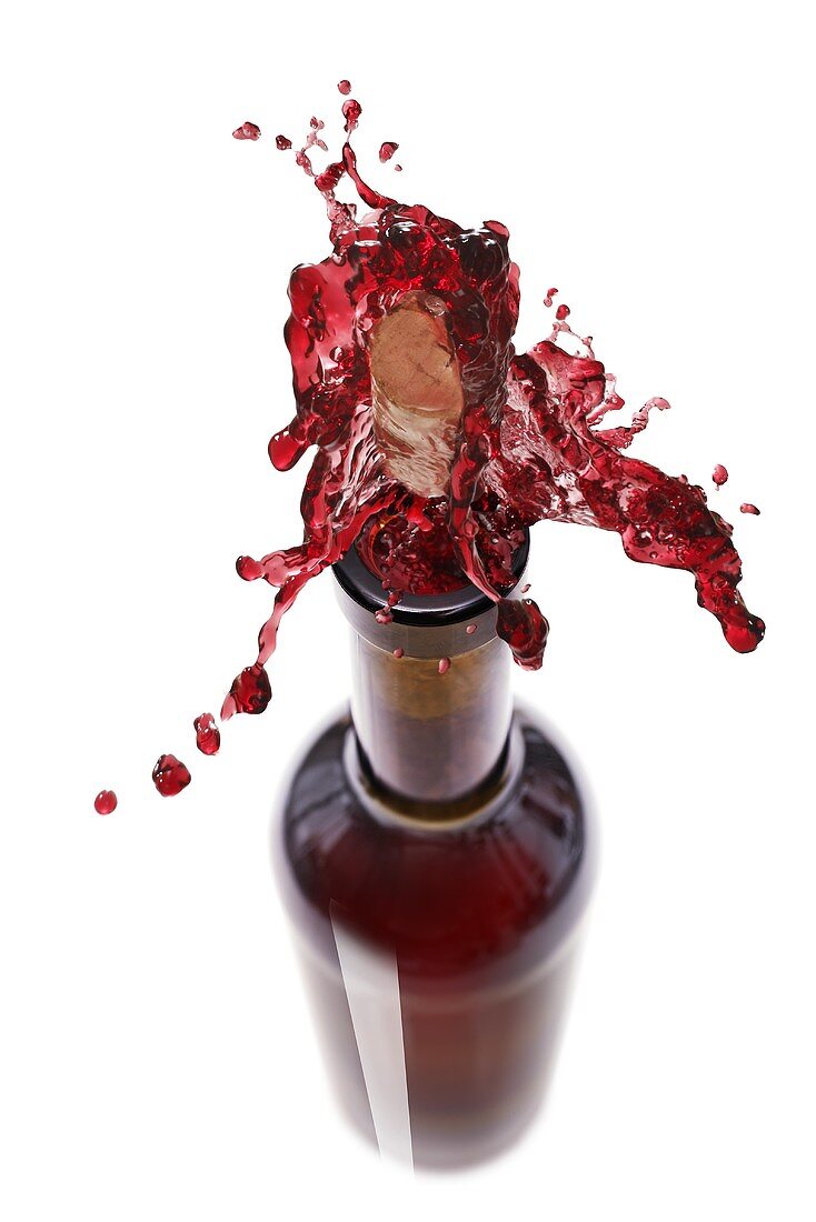 Rotwein spritzt aus der Flasche