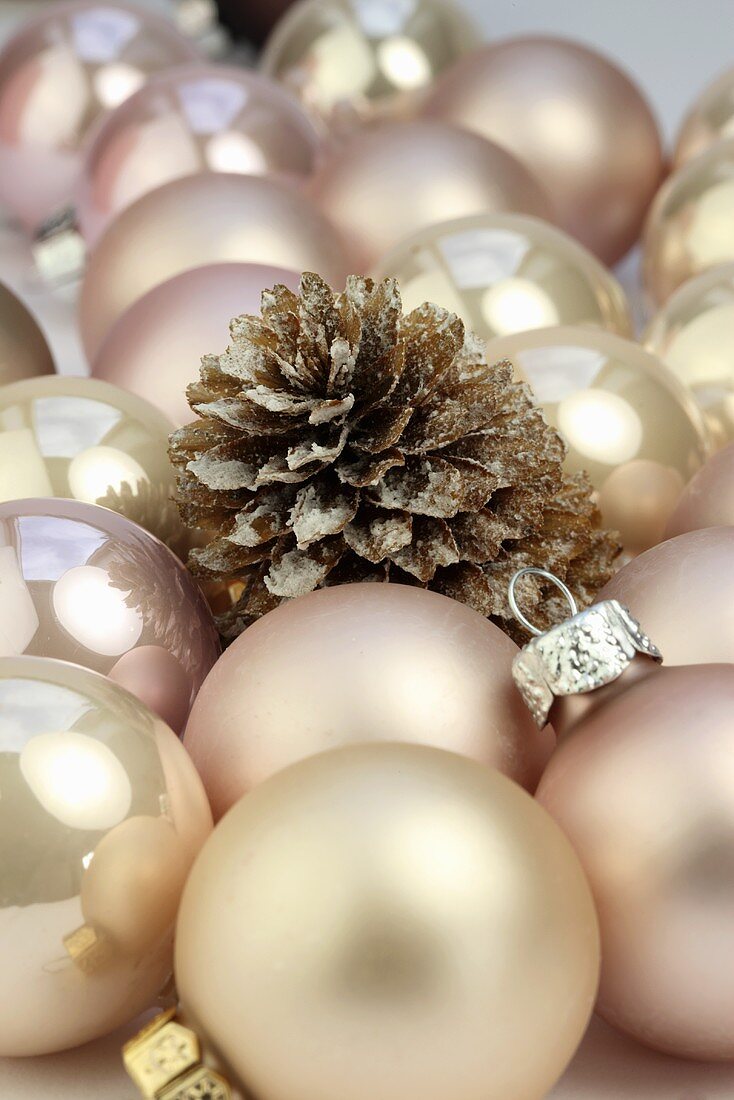 Pink Christmas baubles and a pine cone