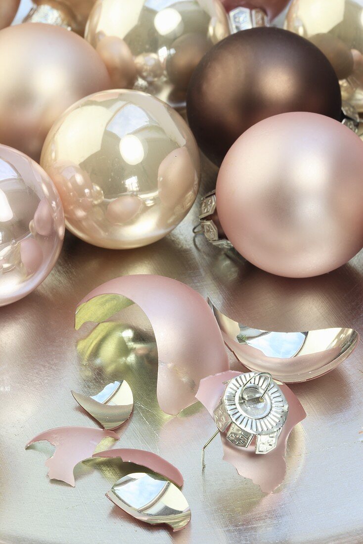 Pink Christmas baubles and one broken on