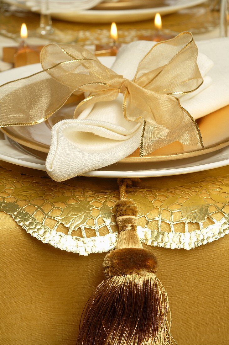 Christmas place-setting with white napkin and gold bow