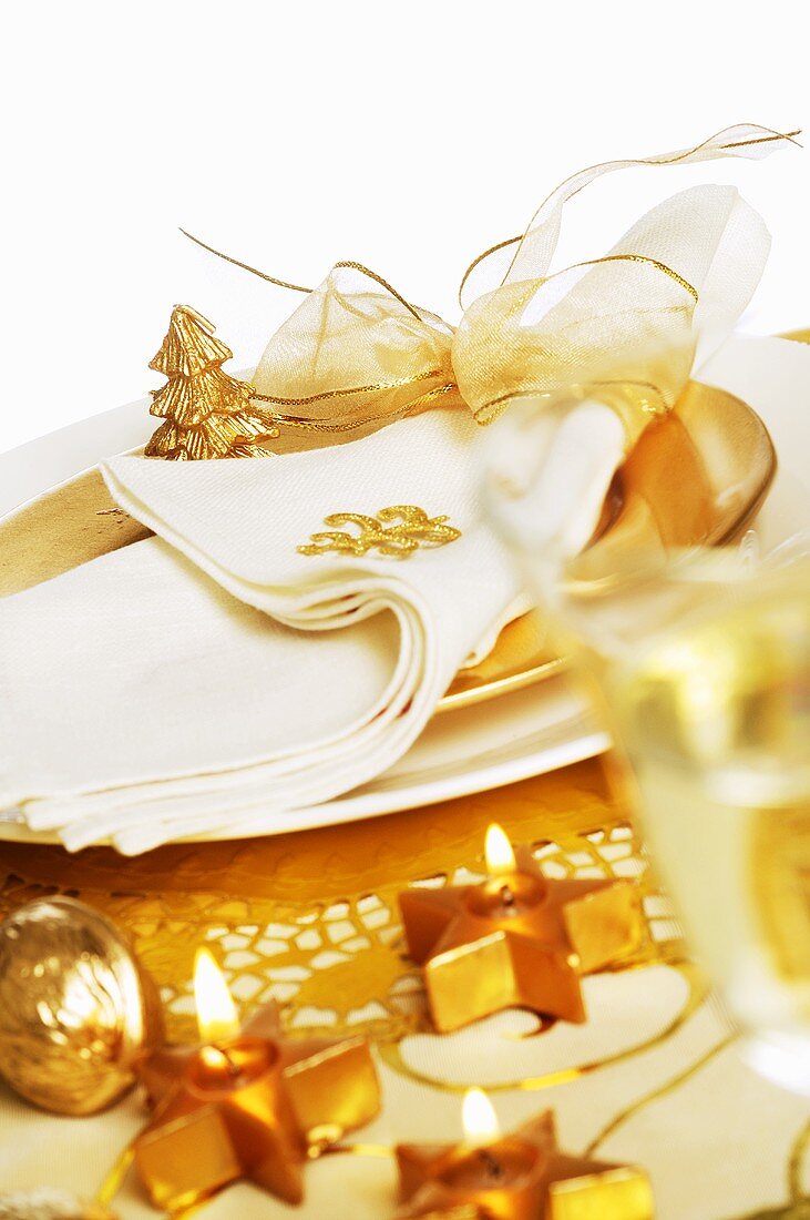 Goldener Weihnachtstisch mit Sternkerzen und Weinglas