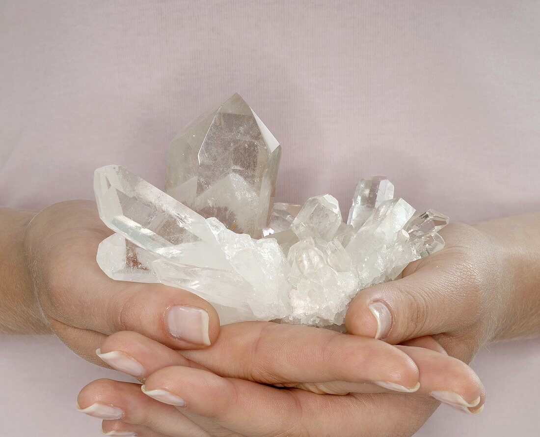 Hands holding quartz crystals