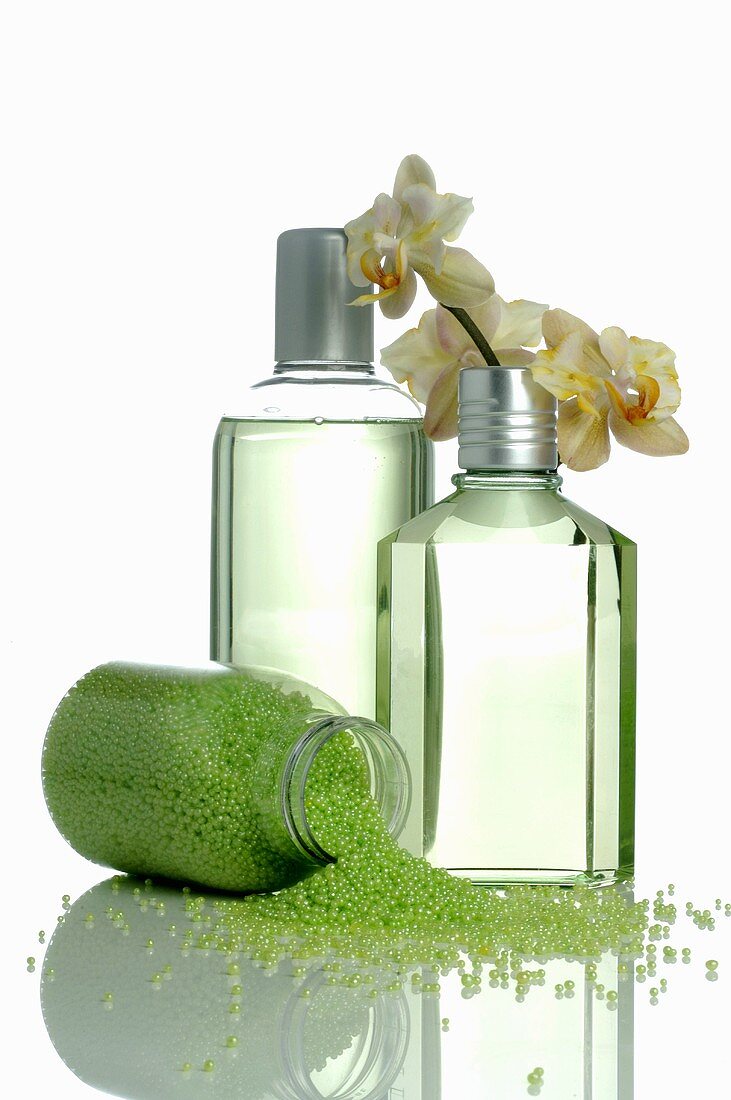 Two cosmetic bottles and green bath salts