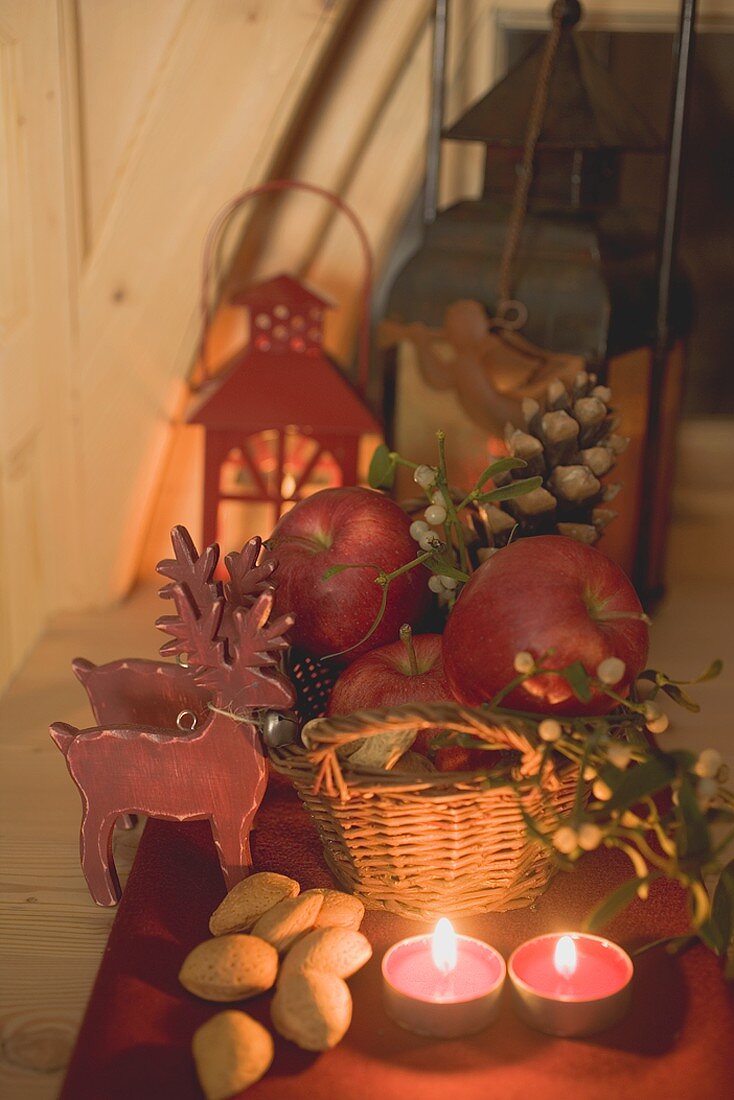 Weihnachtsdeko mit Äpfeln, Nüssen, Kerzen und Rentieren