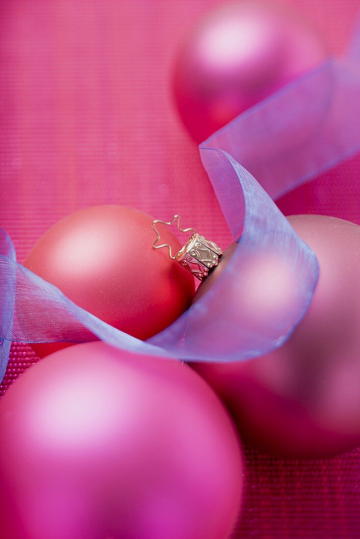 Pinkfarbene Christbaumkugeln mit blauer Schleife