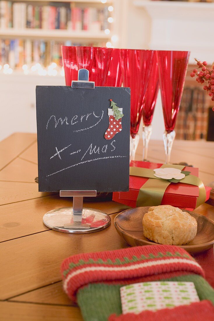 Weihnachtsdeko, Gläser und Gedeck am Esstisch vor Kamin