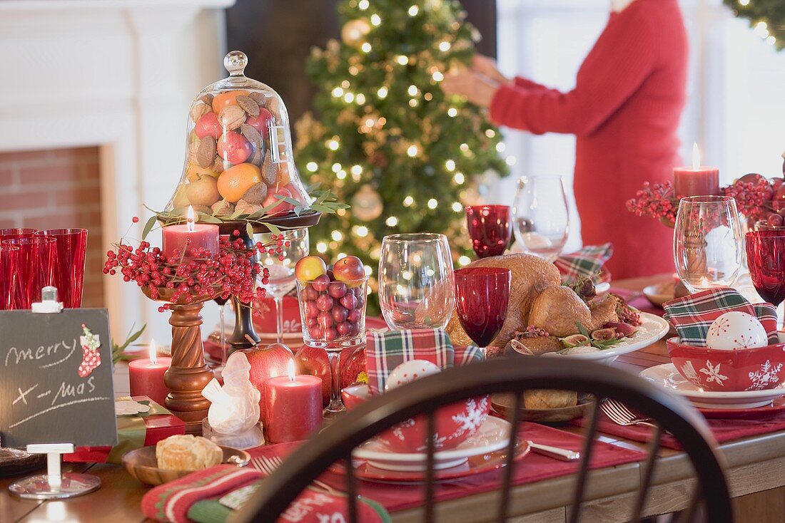 Weihnachtlich gedeckter Tisch, Frau im Hintergrund (USA)