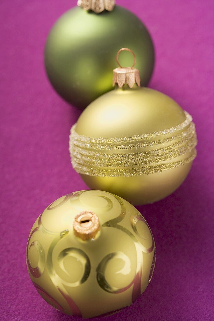 Three different Christmas baubles (green and gold)