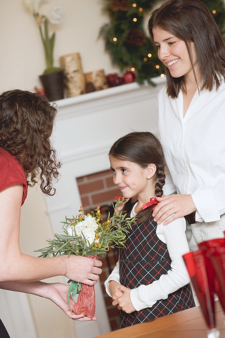Two women and small girl in front of fireplace (Christmas)
