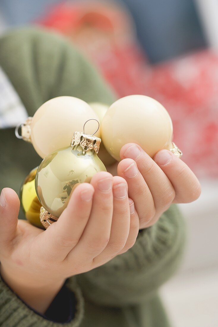 Small boy holding Christmas baubles