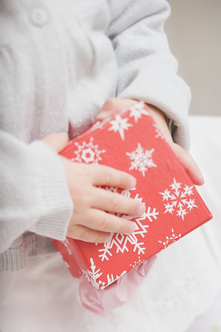 Small girl holding box with snowflake motifs