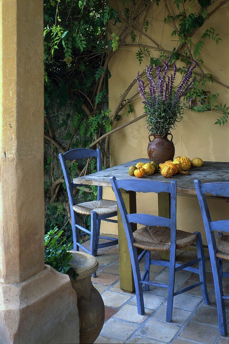 Tisch mit Zierkürbissen und Lavendelblüten auf der Terrasse