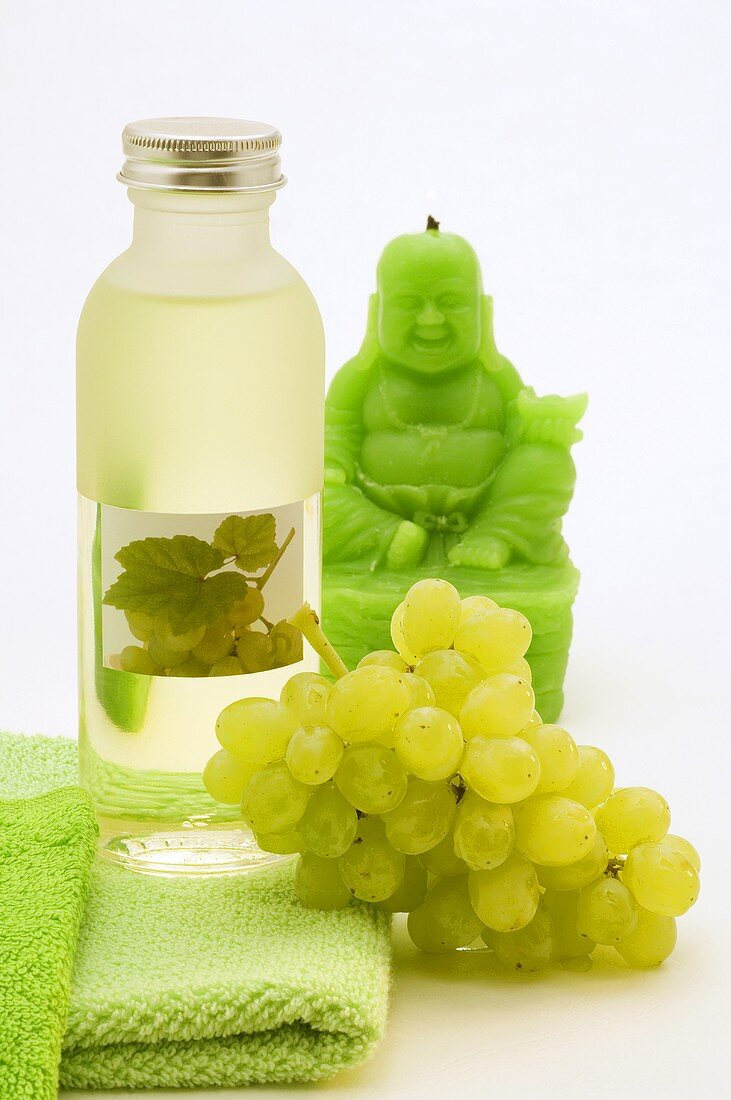 Weisses Traubenkernöl, Weintrauben und grüne Buddha-Kerze