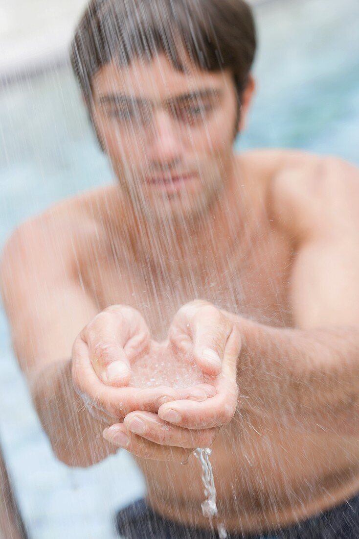 Young man standing under shower