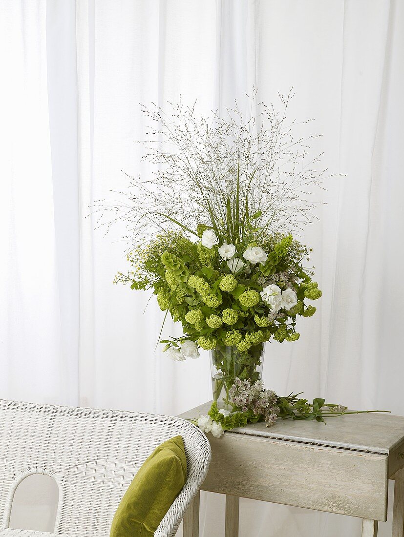 Arrangement of lisianthus and viburnum on side table