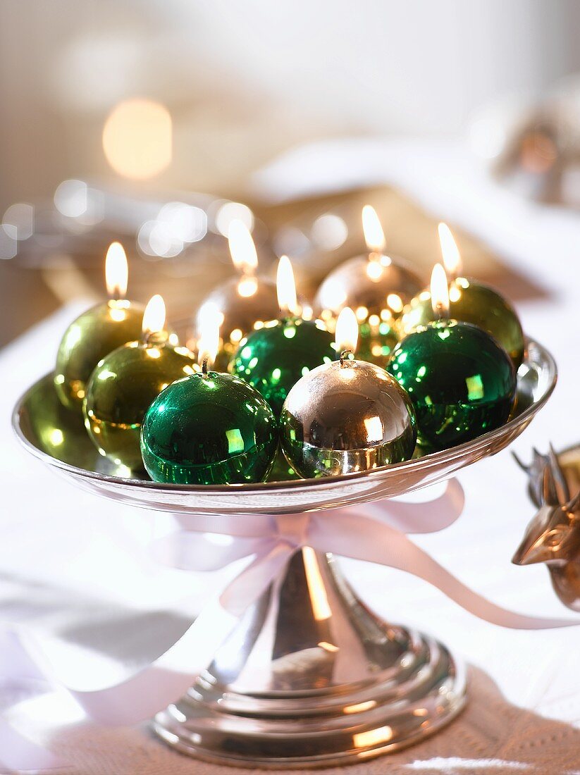 Shiny Christmas bauble candles on a silver stand