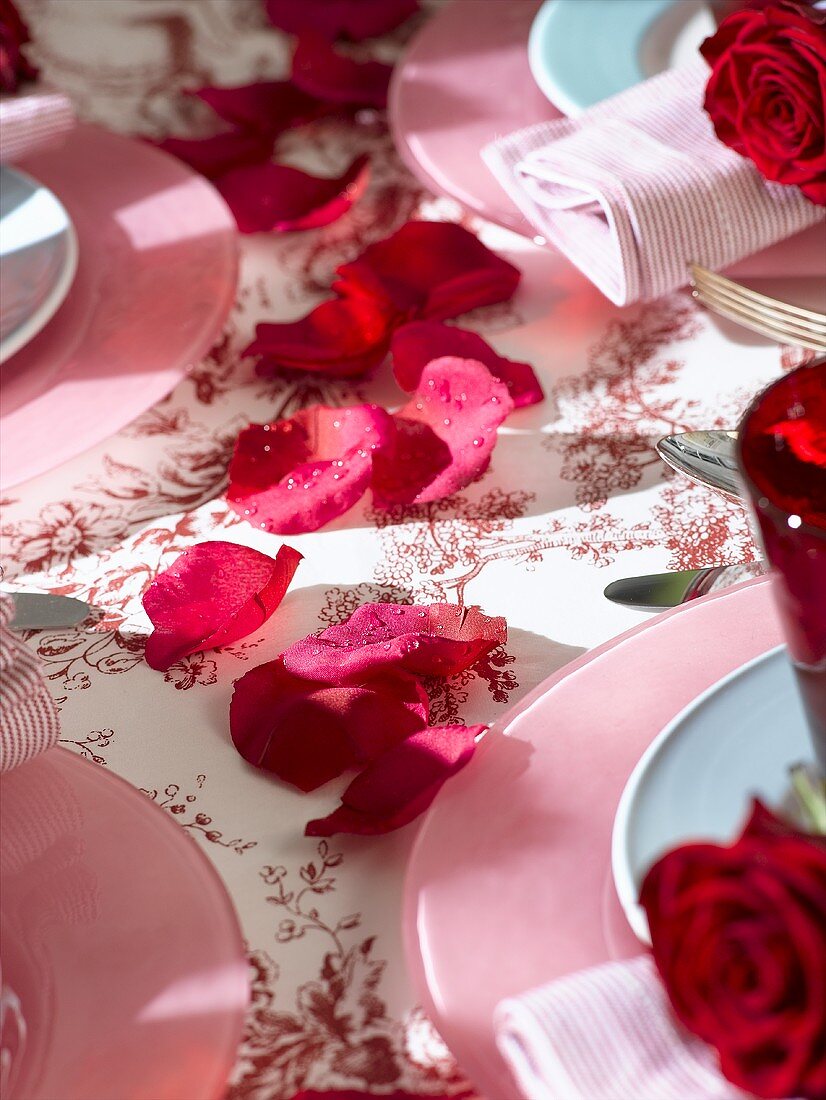 Rote Rosenblütenblätter als Tischdekoration