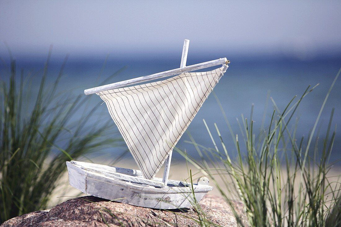 Toy sailing boat by the sea