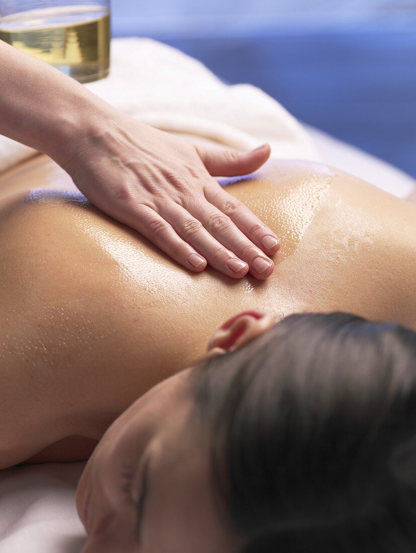 Frau wird mit Massageöl massiert