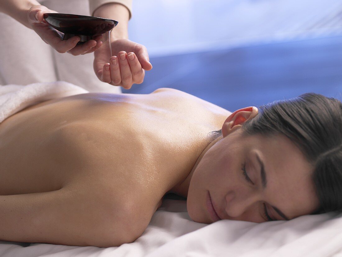 Frau wird mit Massageöl massiert